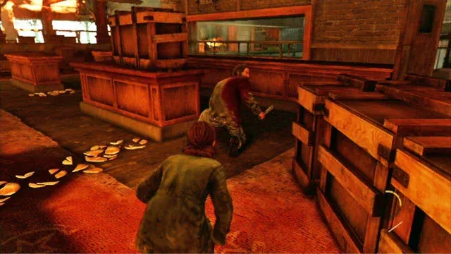 Ellie and David in a scene from the video game, 'The Last of Us' (2013). We are in gameplay view over Ellie's shoulder. She is crouched in her green jacket stalking David, a white man with black hair and a black beard. He's injured (blood drenches half his shirt), and he's crouched facing away from Ellie with a knife in his hands.