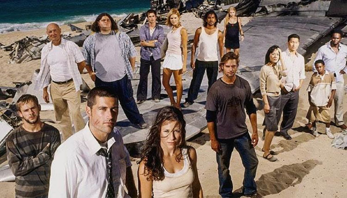 Promotional image of the cast of 'lost.' The whole cast is standing on a beach. There are 14 cast members.